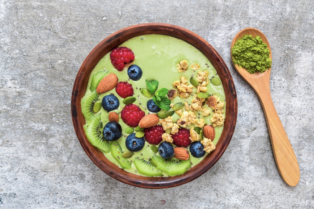 A bowl of matcha and berries which are high in polyphenols and suitable for overcoming brain fog