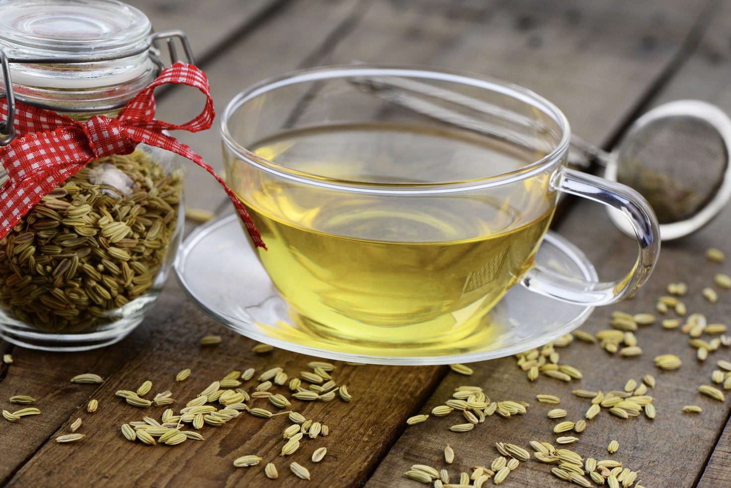 cups of fennel tea with glass jar of fennel seeds and red ribbon