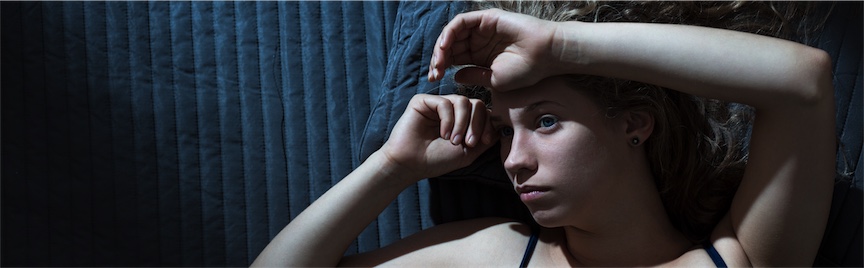 woman lying on bed who can't sleep