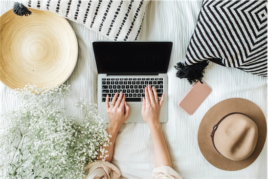 Naturopath writing a blog on a laptop