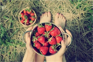 Naturopath holding a bowl of strawberries 