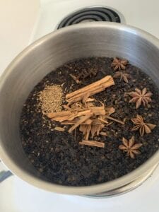 Elderberry, cinnamon, star anise and cloves in a saucepan