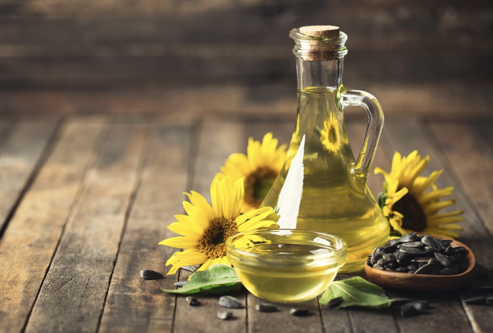 Bottle of sunflower oil with sunflowers and sunflower seeds